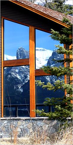 The Rocky Mountains of Canmore Alberta reflected in a residential window